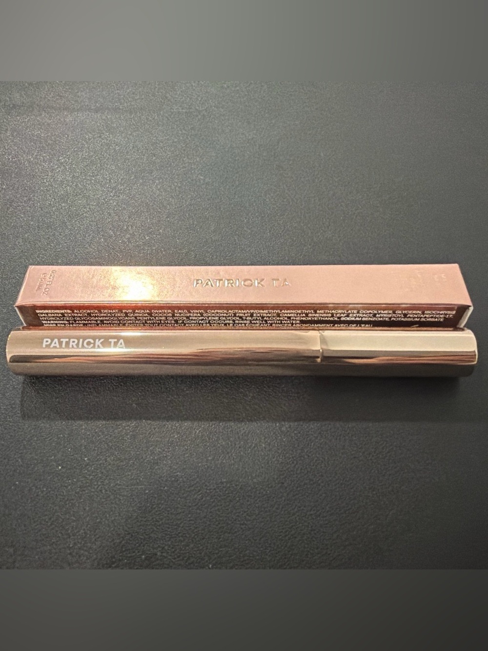 Patrick Ta Rose Gold Cosmetic Tube. Product is Clear.